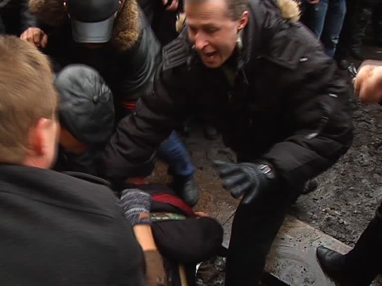 Скриншот видео. Мужчина хватает парня за голову