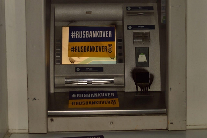 На фотографиях видно, что витрины и двери различных банковских отделений и банкоматов обклеили листовками с хэштегом #RUSBANKOVER, разрисовали граффити, а сами банкоматы (а кое-где и входные двери) залили монтажной пеной. Фото: azov.press