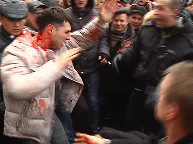 Скриншот видео. Люди избивают человека в крови