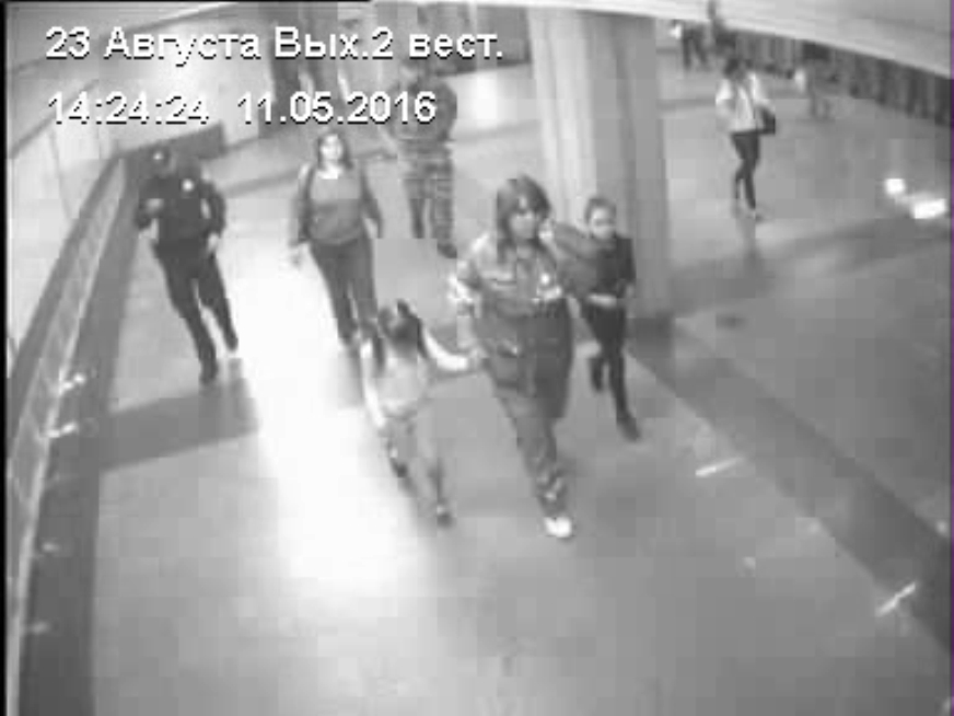 Кадр с камер видеонаблюдения. Женщина и дети в сопровождении полиции и медиков