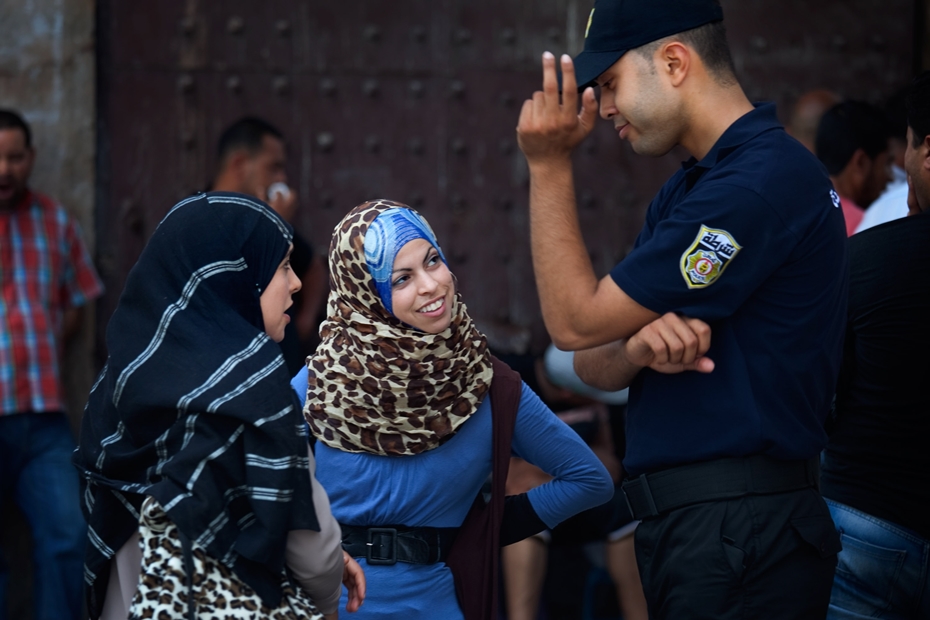 Тунисские девушки и полицейский. Фото: John W. Poole
